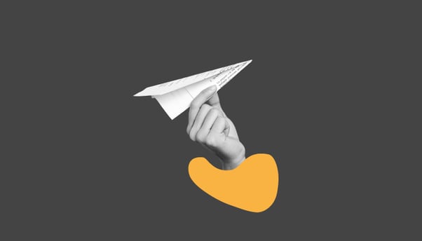 Uma mão segurando um avião de papel