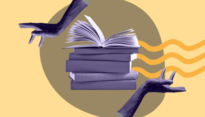 Duas mãos em volta de uma pilha de livros.