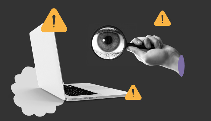 Um computador e uma mão segurando uma lupa.