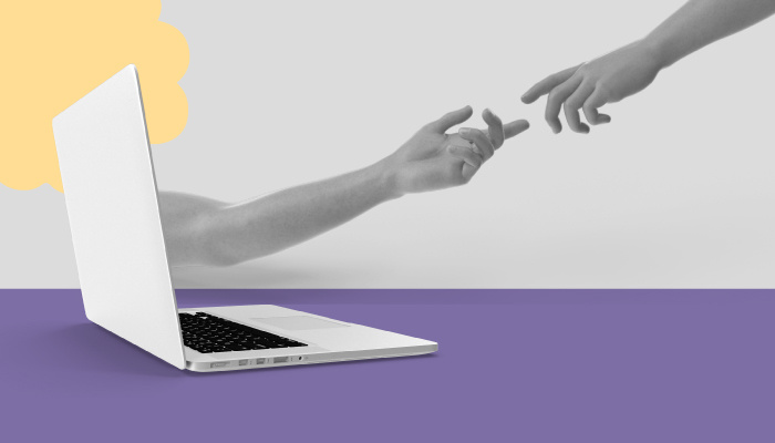 Um braço sai de um notebook. A mão toca em outra mão que vem em sua direção.