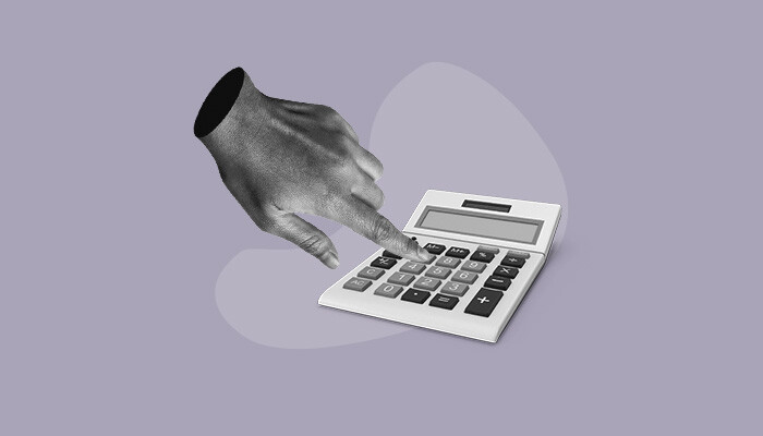 Uma mão realizando cálculos em uma calculadora.