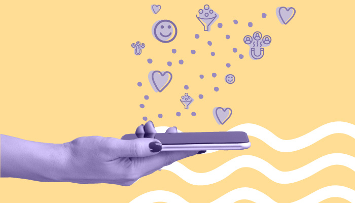 Uma mão segura um smartphone, de onde saem diversos ícones sociais.