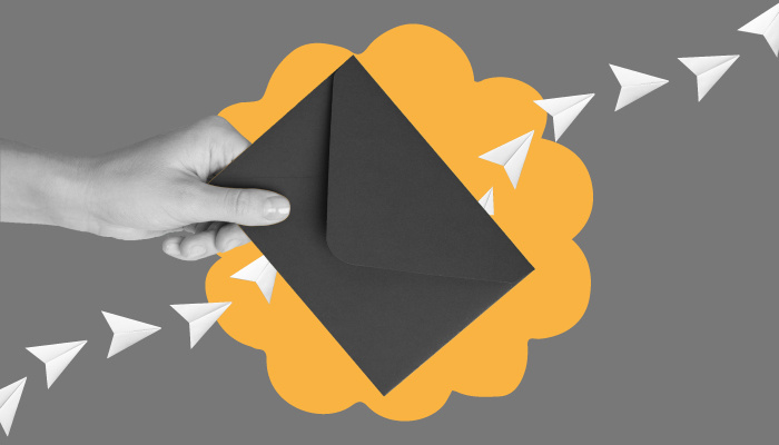 Uma mão segura um envelope preto.