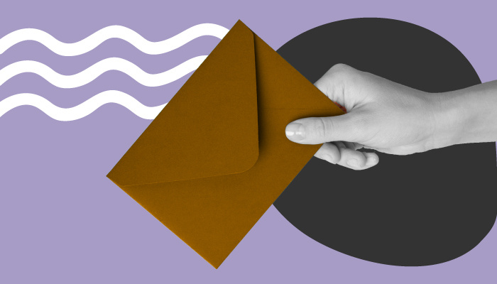 Uma mão segurando um envelope de carta.