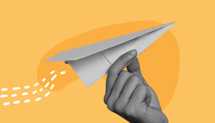 Ilustração: uma mão segura um aviãozinho de papel.