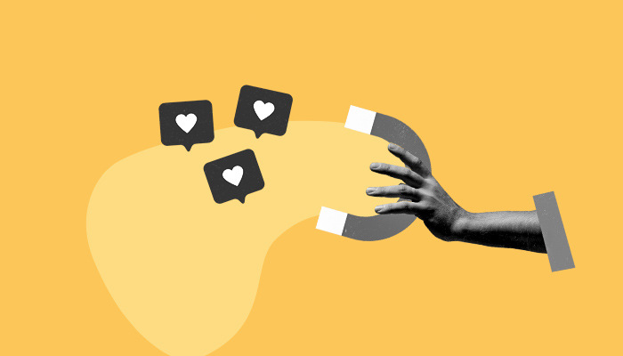 Uma mão segura um íma que atrai diversos ícones sociais de "curtir".