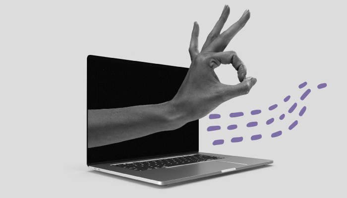 Uma mão sai de um notebook e faz um sinal de "peteleco".