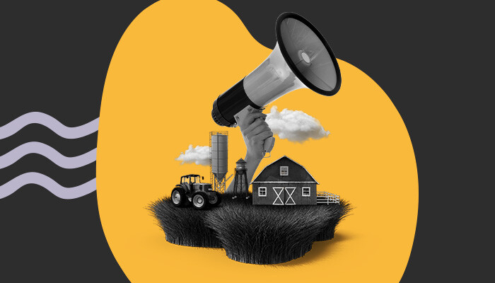 Imagem abstrata: uma mão gigante segura um megafone sobre um cenário agrícola.